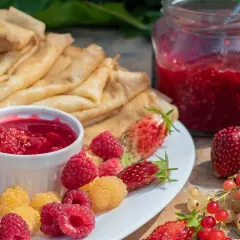 Färska hallon, jordgubbar och vinbär till ett härligt hallonsylt recept. Pannkakor och sylt i en härlig sommardukning.
