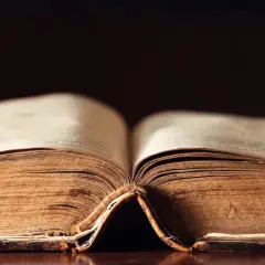 Stary, pożółkły tom księgi otwarty na środku, przypominający o tym, kiedy powstał Stary Testament.