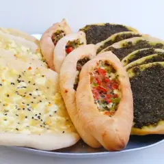 En bricka med manakish zaatar, ost och grönsaksfyllning.