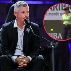 Sędzia na bieżni, w tle kobieta w zielonej koszulce i piłka tenisowa.