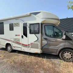 Camping car avec salle de bain à l'arrière, prêt pour l'aventure.