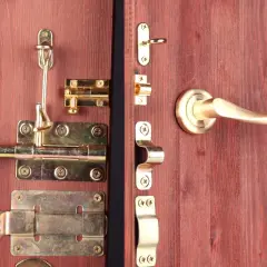 Detalle de varios tipos de pestillos para puertas de madera, con acabados dorados y plateados, listos para instalar.