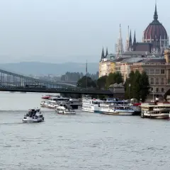 Dunaj miasta, z mostem Łańcuchowym i Parlamentem w tle. Kilka statków wycieczkowych cumuje przy brzegu.