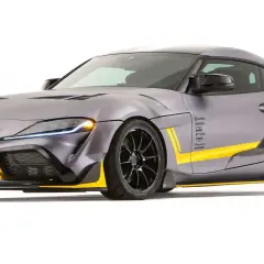 Toyota Supra gris con kit aerodinámico y detalles amarillos, un verdadero deportivo con motor BMW.