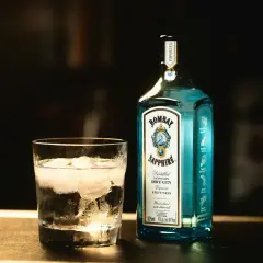 Szklanka z lodem i butelka Bombay Sapphire. Idealny na dobry tani gin na wieczór.