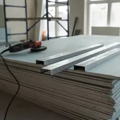 Materiali per un tutorial cartongesso: lastre, profili metallici e smerigliatrice.