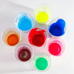 Kolorowe farby w kubeczkach, idealne jako jaka farba do plastiku na zewnątrz. Odcienie czerwieni, niebieskiego, zieleni, żółci, pomarańczu i różu.