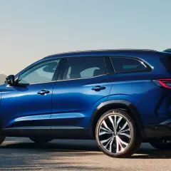 Błękitny Renault Espace 2024 z eleganckimi felgami stoi na tle pustynnego krajobrazu.
