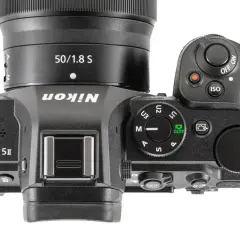 Górna część aparatu Nikon Z5 II z obiektywem 50/1.8 S. Widoczne przyciski sterujące, pokrętło trybów i logo Nikon.