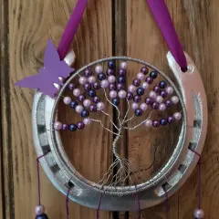 Tuto attrape rêve arbre de vie : un fer à cheval argenté orné d'un arbre de vie en fil de fer et perles violettes et roses, avec un papillon violet.
