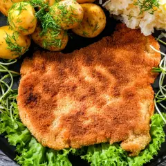 Chrupiący kotlet w panierce panko Lidl, podany z młodymi ziemniaczkami, kiszoną kapustą i kiełkami.