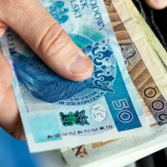 Dłoń trzyma polskie banknoty: 50 zł i 200 zł. Wkrótce trzeba będzie zapłacić czynsz.