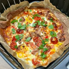 Pyszna tortilla z airfryer, z pomidorkami, serem i ziołami, gotowa do podania.