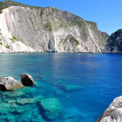 Turkusowe wody Zatoki Wraku, otoczone białymi klifami, tworzą malowniczy krajobraz w okolicach miasta Zakynthos.