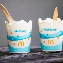 Dwa kubeczki McFlurry z drewnianymi łyżeczkami. Idealne na deser, ale warto sprawdzić mcflurry kcal przed spożyciem.