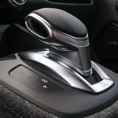 Levier de vitesse d'une b boite auto moderne, avec indicateurs lumineux R, N, D, B. Le design est futuriste et élégant.