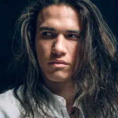 Joven con cabello largo y castaño, con un estilo que resalta el cuidado del cabello hombre.
