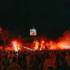 Nocny festiwal w twierdzy z tłumem ludzi i pokazem świateł.