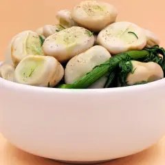 Miseczka pełna bobu z zielonymi ziołami. Zastanawiasz się, ile kcal ma bob? To pyszna i zdrowa przekąska!