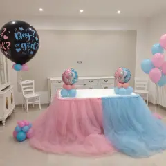 Un allestimento per un baby shower con palloncini rosa e azzurri, che simboleggiano il significato di "boy or girl?".
