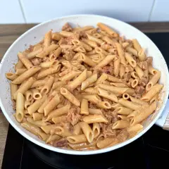 Penne z kremowym sosem i kawałkami pikantnego chorizo, przygotowane na patelni.