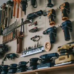Un mur rempli d'outils pour travailler le bois : perceuses, ponceuses, scies sauteuses, ciseaux, marteaux et autres accessoires essentiels pour tout artisan.