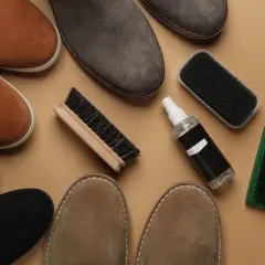 Zamszowe buty w różnych kolorach i akcesoria do ich pielęgnacji: szczotki i spray.