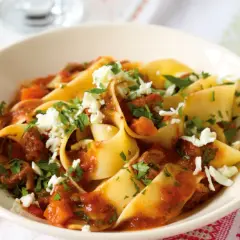 Breite Bandnudeln mit einer herzhaften Rinderhackfleischsauce und zerbröseltem Käse, ein klassisches italienisches Gericht.