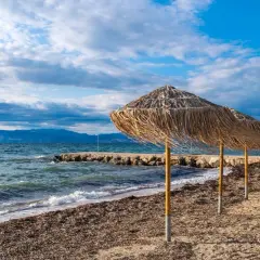 Słomiane parasole na plaży, idealne na relaks. Warto przeczytać angela beach opinie przed podróżą.