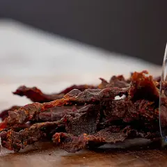 Leckeres beef jerky selber machen ist gar nicht schwer! Hier ist ein Haufen selbstgemachtes Beef Jerky, das aus einem Glas gekippt wurde.