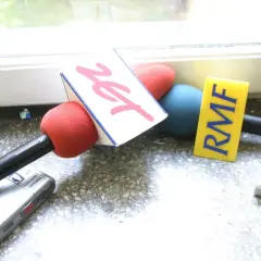 Mikrofony z logotypami RMF FM i Zet, rejestrator dźwięku i odtwarzacz MP3 na parapecie.