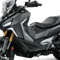 Scooter todo terreno gris oscuro con detalles plateados, asiento negro y parabrisas alto. ¡Listo para la aventura!