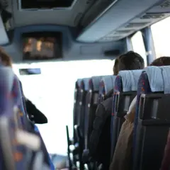 Wygodny transport gości weselnych autobusem. Widok z wnętrza pojazdu na siedzących pasażerów.