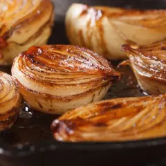 Cebolla caramelizada dorada y jugosa en una sartén.