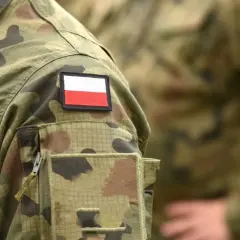 Fragment munduru wojskowego z naszywką z flagą Polski.