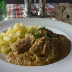 Sabrosa carne guisada con verduras y patatas, servida en un plato blanco.