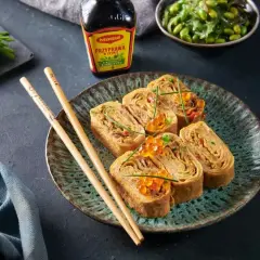 Roladki omlet tamago z ikrą łososia i szczypiorkiem, podane z pałeczkami i sosem Maggi.