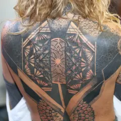 Niesamowity tatuaż 3d na plecach, pełen geometrycznych wzorów i cieniowania, tworzący iluzję głębi.