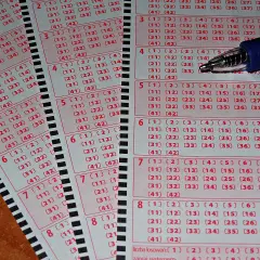 Kupony gry Multi Multi Plus z zaznaczonymi liczbami i długopisem.