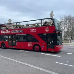 Roter Doppeldeckerbus für Barcelona Hop-On Hop-Off Touren fährt auf der Straße. Touristen genießen die Aussicht von oben.