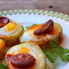 Canapés con huevo de codorniz y chorizo, horneados en rodajas de patata. Un bocado delicioso y original.