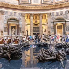 Intérieur du Panthéon de Rome, avec des sculptures modernes sur l'eau reflétant l'architecture antique.