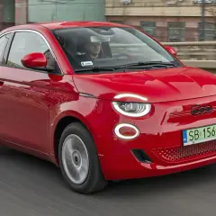 Czerwony Fiat 500 jedzie po drodze. Sprawdź aktualną fiat 500 cena i wybierz swój wymarzony model!