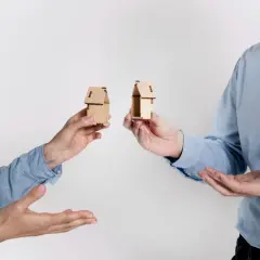 Rozdzielność majątkowa a wspólny dom: dwoje ludzi trzyma miniaturowe domki, symbolizujące podział majątku.