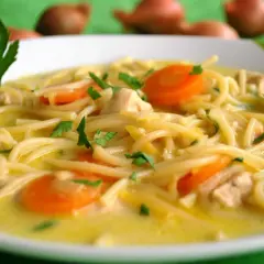 Aromatyczna zupa cytrynowa z kurczakiem, makaronem i marchewką, udekorowana natką pietruszki. Idealna na chłodne dni.