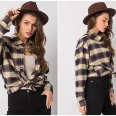 Modelka w brązowym kapeluszu i flanelowej koszuli w kratę, styl grunge.
