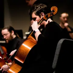 Une musicienne joue du contrebasse dans un orchestre.