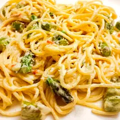 Pyszne spaghetti ze szparagami w kremowym sosie, posypane parmezanem. Idealne danie na wiosnę.