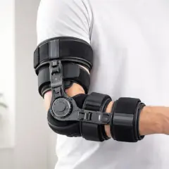 Mann legt eine Ellenbogenorthese richtig an. Die Orthese stützt und stabilisiert das Gelenk.