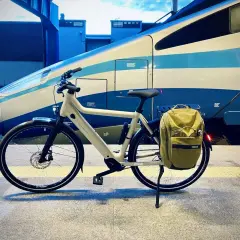 Biały rower z sakwą czeka na peronie. To idealny środek transportu, gdy kolej na rower!